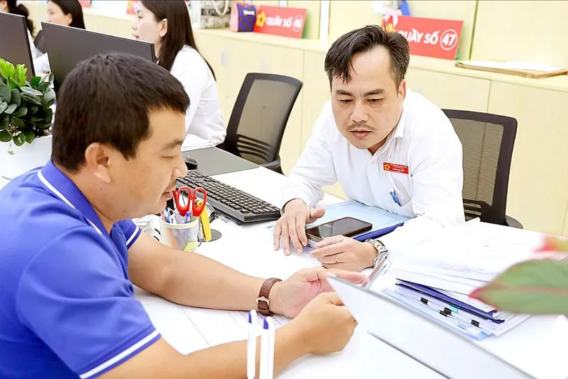 Cán bộ hướng dẫn thủ tục cho người dân tại Trung tâm Phục vụ hành chính công TPHCM (ẢNH: LÊ THOA)