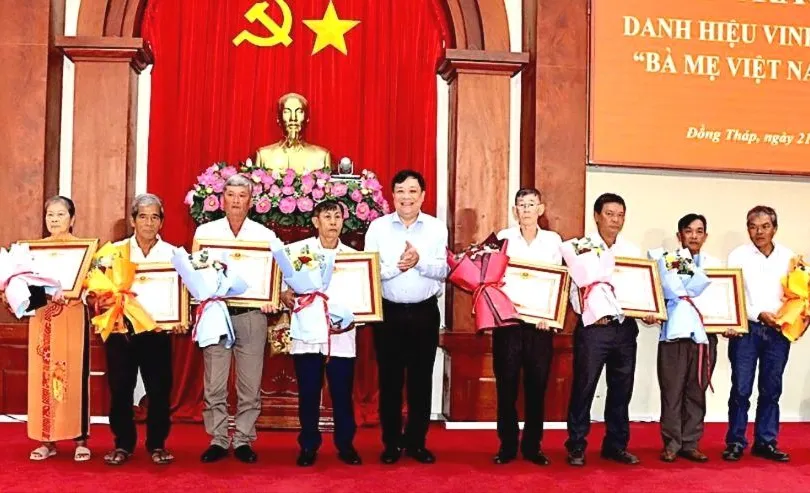 Đồng chí Phạm Thành Ngại, Chủ tịch UBND tỉnh Đồng Tháp, trao bằng công nhận và hoa cho thân nhân các Bà mẹ Việt Nam Anh hùng. Ảnh: VIỆT TIẾN