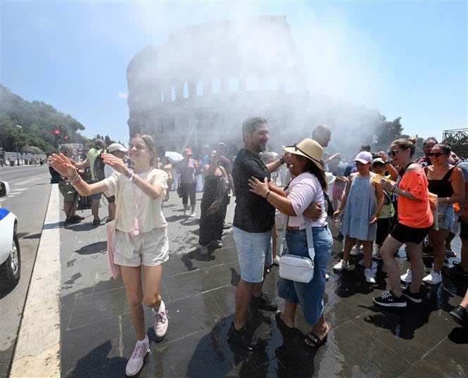 2026年6月26日，在意大利罗马，当地民众在炎热天气中靠近喷雾装置来降温。越通社