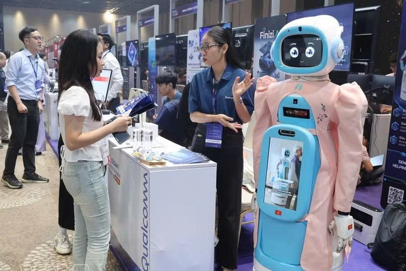 参观者在Qualcomm展台了解老年人护理机器人模型。图自越通社