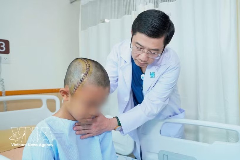 胡志明市医药大学医院神经外科主任张青情检查患者情况。图自越通社 
