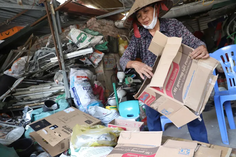 Bà Nguyễn Thị Hoa đang nhặt phế liệu tại căn nhà vừa tháo dỡ. Ảnh: TIẾN CƯỜNG