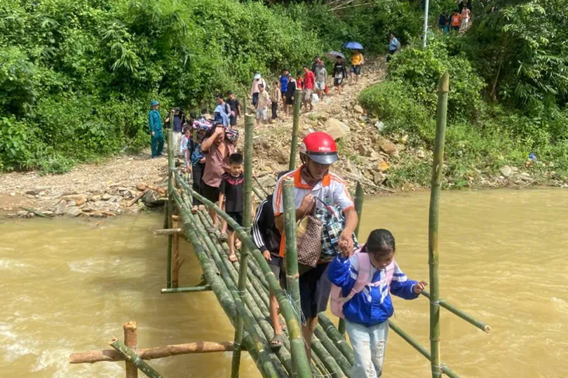 Học sinh được lực lượng chức năng hỗ trợ qua cầu tạm để kịp đến trường trong buổi học đầu tuần