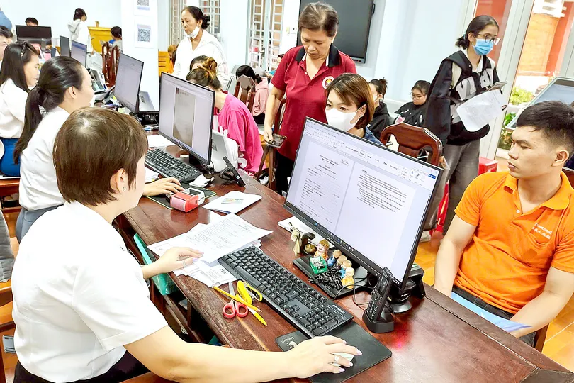 Chuyên viên Trung tâm Phục vụ hành chính công phường Đông Hòa tiếp và giải quyết thủ tục hành chính của người dân. Ảnh: THU HƯỜNG