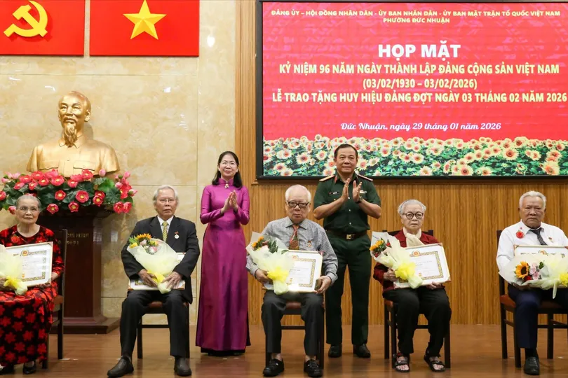 Thiếu tướng Vũ Văn Điền và đồng chí Phan Thị Thanh Phương trao Huy hiệu Đảng đến các đảng viên