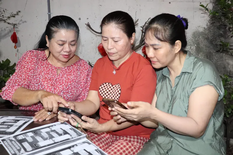 Bà Đào Thị Lan Phương, Trưởng Khu phố 11, phường Bình Thạnh (TPHCM), hướng dẫn người dân tạm trú đăng ký nơi bỏ phiếu qua VNeID trong đợt bầu cử vừa qua. Ảnh: THÁI PHƯƠNG 