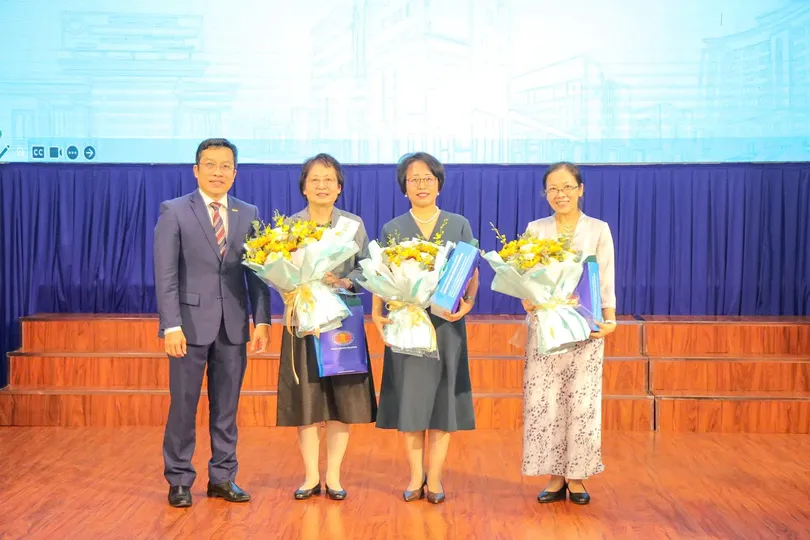 Đại diện Trường ĐH Khoa học xã hội và Nhân văn trao hoa và quà lưu niệm đến các chuyên gia tham gia tập huấn.