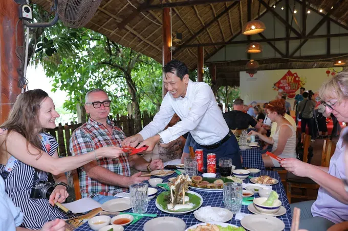 Foreign tourists received lucky money during the “Westerners celebrate Tet in the West” tour, operated by Vietluxtour Travel in the afternoon of February 5 (Photo: SGGP)