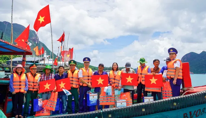 Officers and soldiers of the Coast Guard Region 3 Command are presenting national flags and essential goods to fishermen of the Con Dao Special Zone during the “Coast Guard Accompanying Fishermen” program