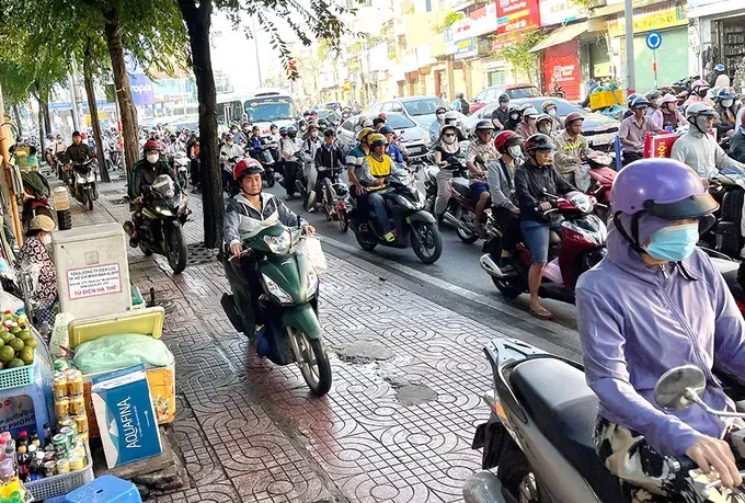 Numerous people are riding motorbikes on the sidewalk along Ly Thuong Kiet Street of Tan Son Nhat Ward (Photo: SGGP)