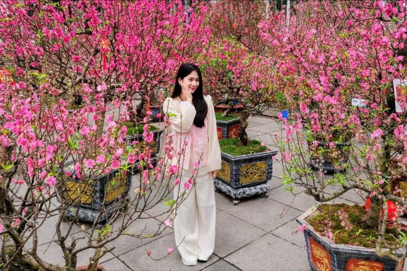 Một bạn trẻ tạo dáng chụp hình bên vườn đào quý ở vườn hoa Lý Thái Tổ. Ảnh: QUỐC KHÁNH