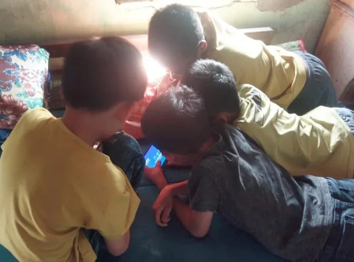 Nhóm trẻ chụm đầu chơi game trên điện thoại trong kỳ nghỉ hè (ẢNH: SƠN VINH)