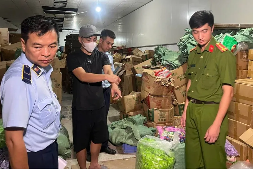 Bị can Nguyễn Quang Đạt (đeo khẩu trang) tại kho hàng. Ảnh: CÔNG AN CUNG CẤP