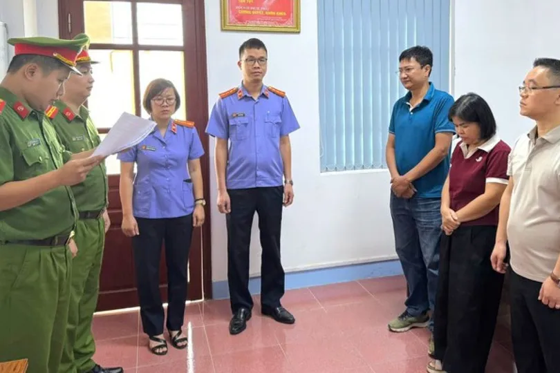 Đại diện Cơ quan Cảnh sát điều tra tống đạt quyết định tố tụng tới các bị can. Ảnh: CÔNG AN CUNG CẤP