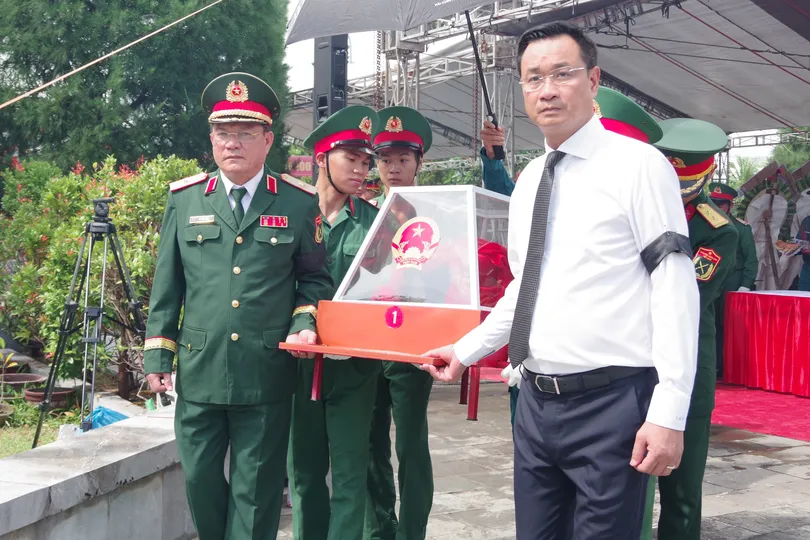 Bí thư Thành ủy Đà Nẵng Lê Ngọc Quang cùng lãnh đạo Bộ Tư lệnh Quân khu 5 thực hiện nghi thức an táng hài cốt liệt sĩ. Ảnh: QUANG CƯỜNG