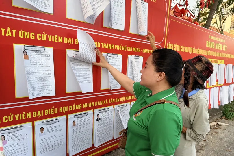 Cử tri xã Tân An Hội xem tiểu sử, chương trình hành động của các ứng cử viên đại biểu Quốc hội khóa XVI, đơn vị bầu cử số 12 tại UBND xã Tân An Hội. Ảnh: HOÀNG HÙNG)