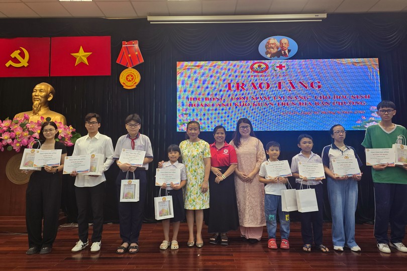 胡志明市华文教育辅助会副主席颜旭君、副主席卢美如向安乐坊华人子弟颁发助学金。