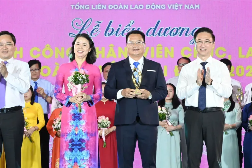 Chủ tịch Tổng LĐLĐ Việt Nam Nguyễn Anh Tuấn và Phó Bí thư Thành ủy TPHCM Đặng Minh Thông chúc mừng các gia đình được biểu dương. Ảnh: VIỆT DŨNG