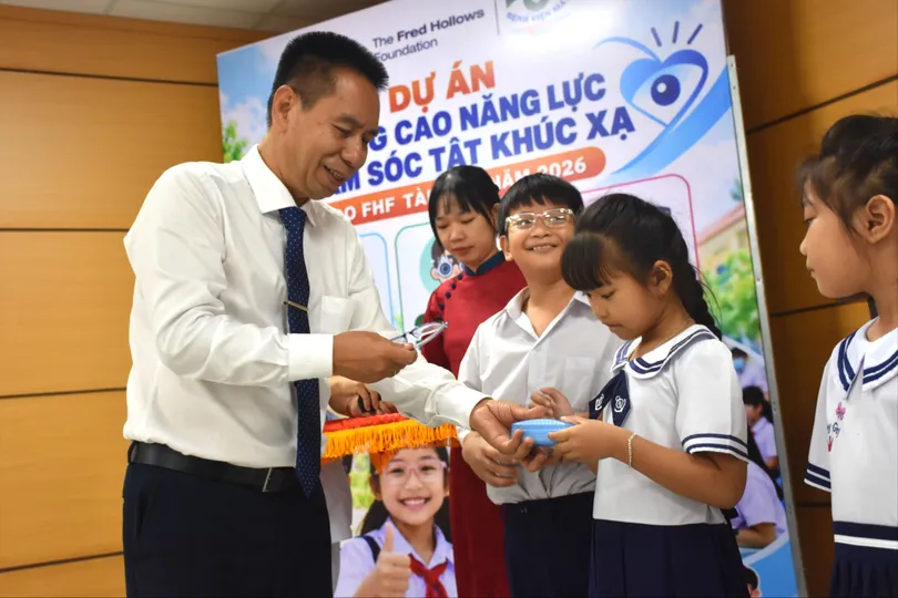 TTND. Nguyễn Viết Giáp trao tặng kính cho các em học sinh.