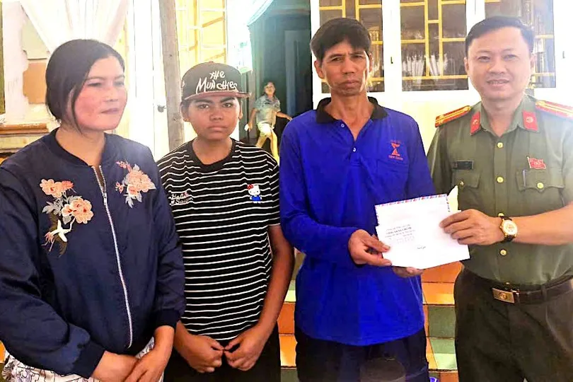 Lãnh đạo Công an xã Chư Sê, tỉnh Gia Lai thay mặt bạn đọc Báo SGGP trao tiền hỗ trợ cho gia đình