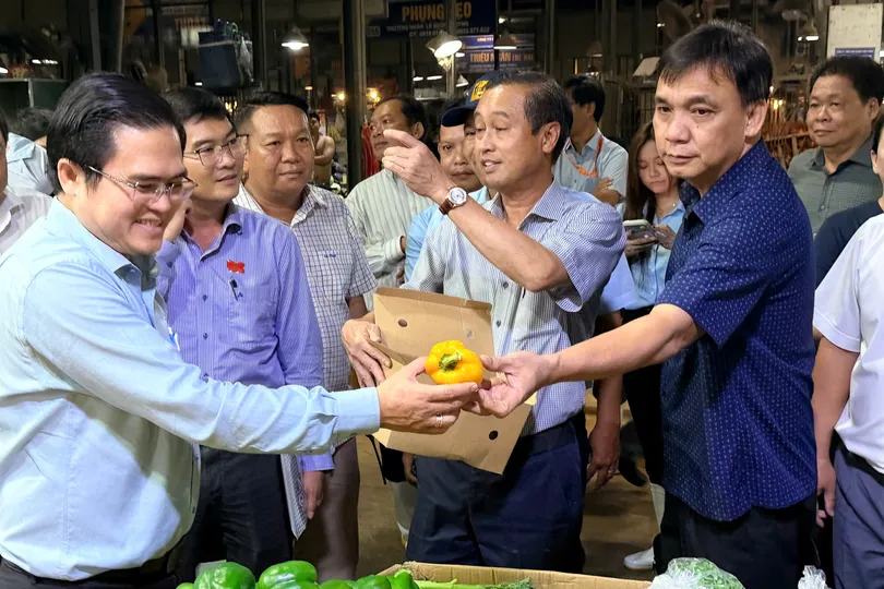 Đoàn khảo sát giám sát hàng rau củ quả tại chợ Bình Điền. Ảnh: HOÀNG HÙNG