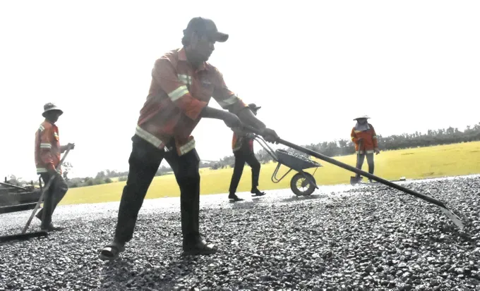 Workers are laying asphalt concrete on the surface of the Chau Doc – Can Tho – Soc Trang Expressway section passing through An Giang Province. (Photo: SGGP)