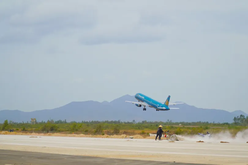 Workers use sweeping machines to clean the newly built runway at Phu Cat Airport. (Photo: SGGP)