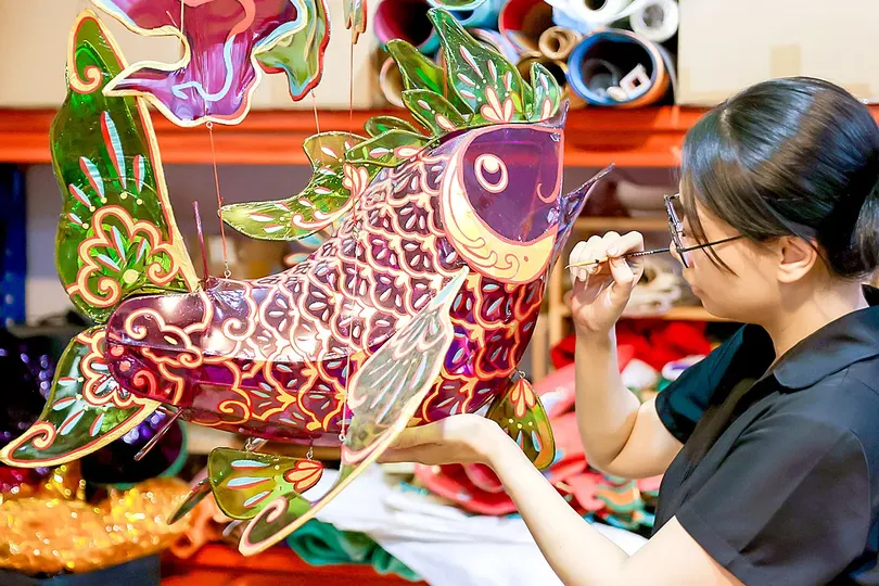 Artisan Nguyen Thi Kim Thuy puts the finishing touches on a carp-shaped lantern. (Photo: SGGP)