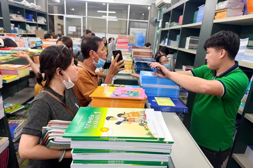 Phụ huynh mua SGK cho con tại trụ sở NXBGDVN tại TPHCM vào trưa 15-9. Ảnh: HOÀNG HÙNG