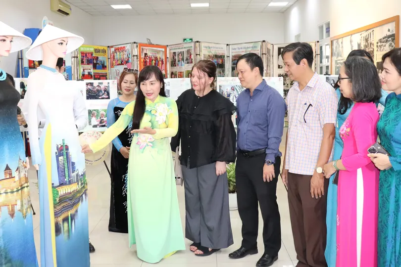 Bà Trịnh Thị Thanh giới thiệu về chiếc áo dài truyền thống Việt Nam đến bà Palina Karpava, Phó Tổng Lãnh sự Belarus tại TPHCM. Ảnh: THÁI PHƯƠNG