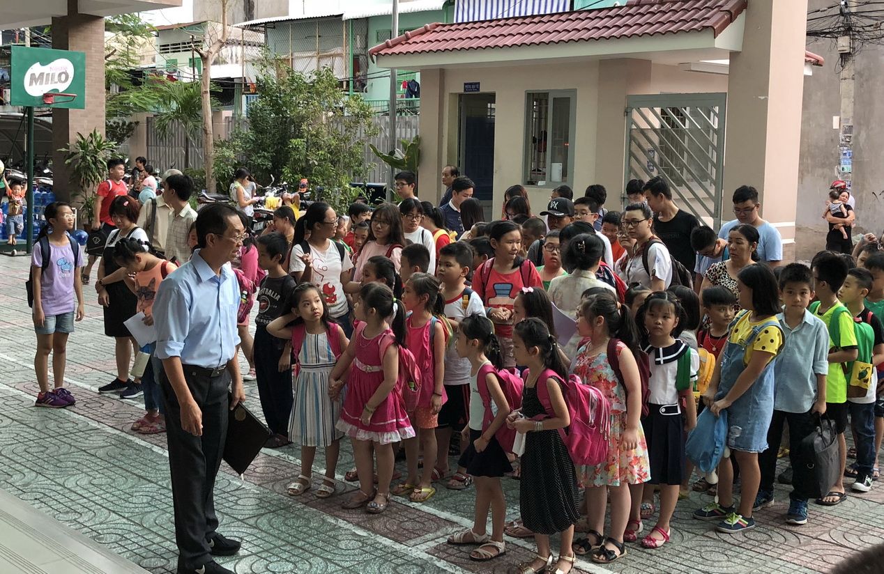 该中心暑期班学生排队进入课室.