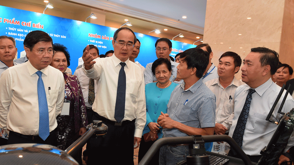HCMC Party Chief Nguyen Thien Nhan and People’s Committee Chairman Nguyen Thanh Phong see industrial products displayed at the workshop (Photo: SGGP)