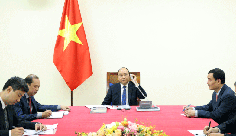Prime Minister Nguyen Xuan Phuc (C) at the phone talks with his Japanese counterpart Suga Yoshihide on October 12 (Source: VGP)