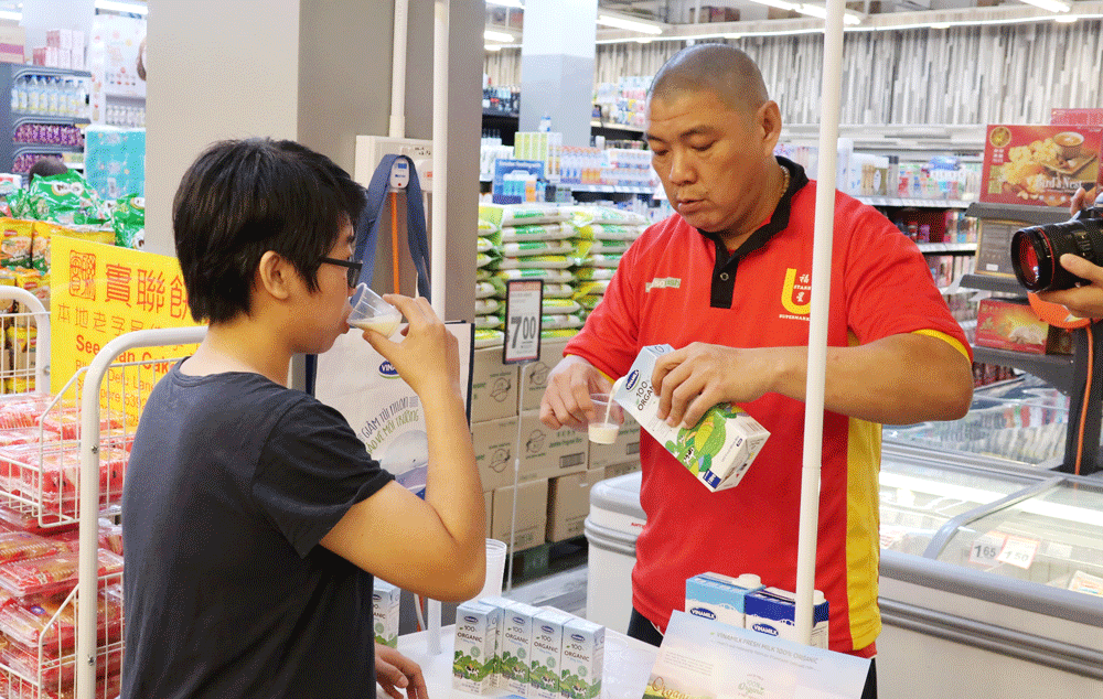 Người tiêu dùng Singapore tìm hiểu về sữa tươi Organic tại quầy dùng thử sản phẩm sữa Vinamilk trong các siêu thị