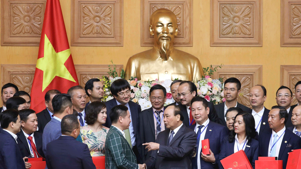 Thủ tướng Nguyễn Xuân Phúc tặng quà lưu niệm cho các doanh nhân tiêu biểu. Ảnh: TTXVN
