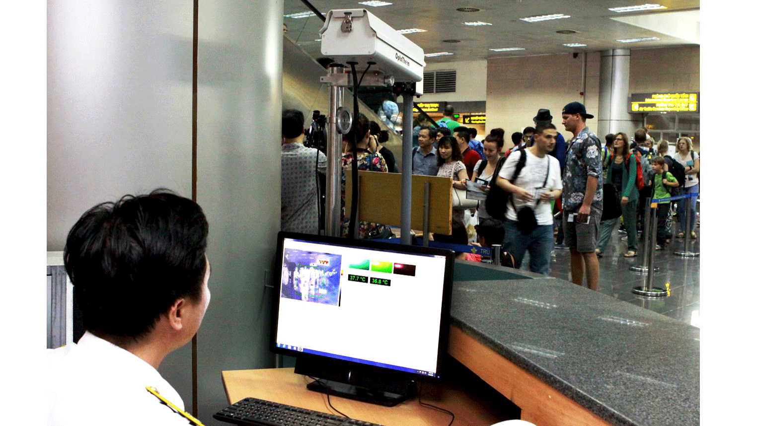 Cán bộ kiểm dịch y tế tại sân bay quốc tế Nội Bài dùng máy đo thân nhiệt từ xa kiểm tra sức khỏe khách nhập cảnh