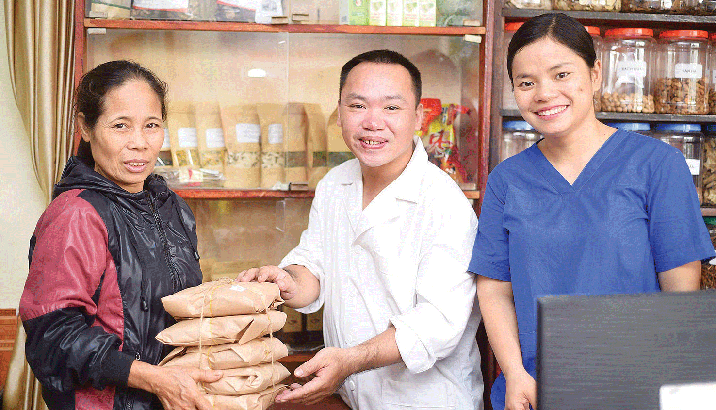 Vợ chồng bác sĩ Phạm Đình Vinh (Phòng khám Khương Sơn, Hà Nội) trao thuốc tặng miễn phí bệnh nhân nghèo. Ảnh: VĂN CÔNG 