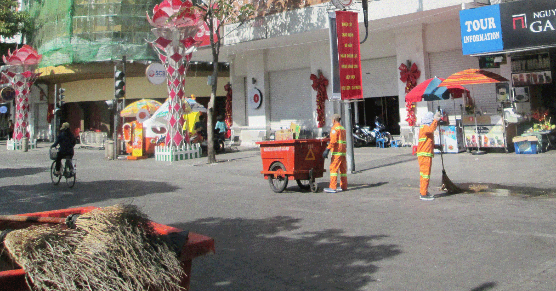 Trưa mùng 1 Tết, trên đường Nguyễn Huệ (quận 1, TPHCM), các công nhân vệ sinh vẫn miệt mài quét dọn đường phố . Ảnh: HOÀNG THÁI HÙNG