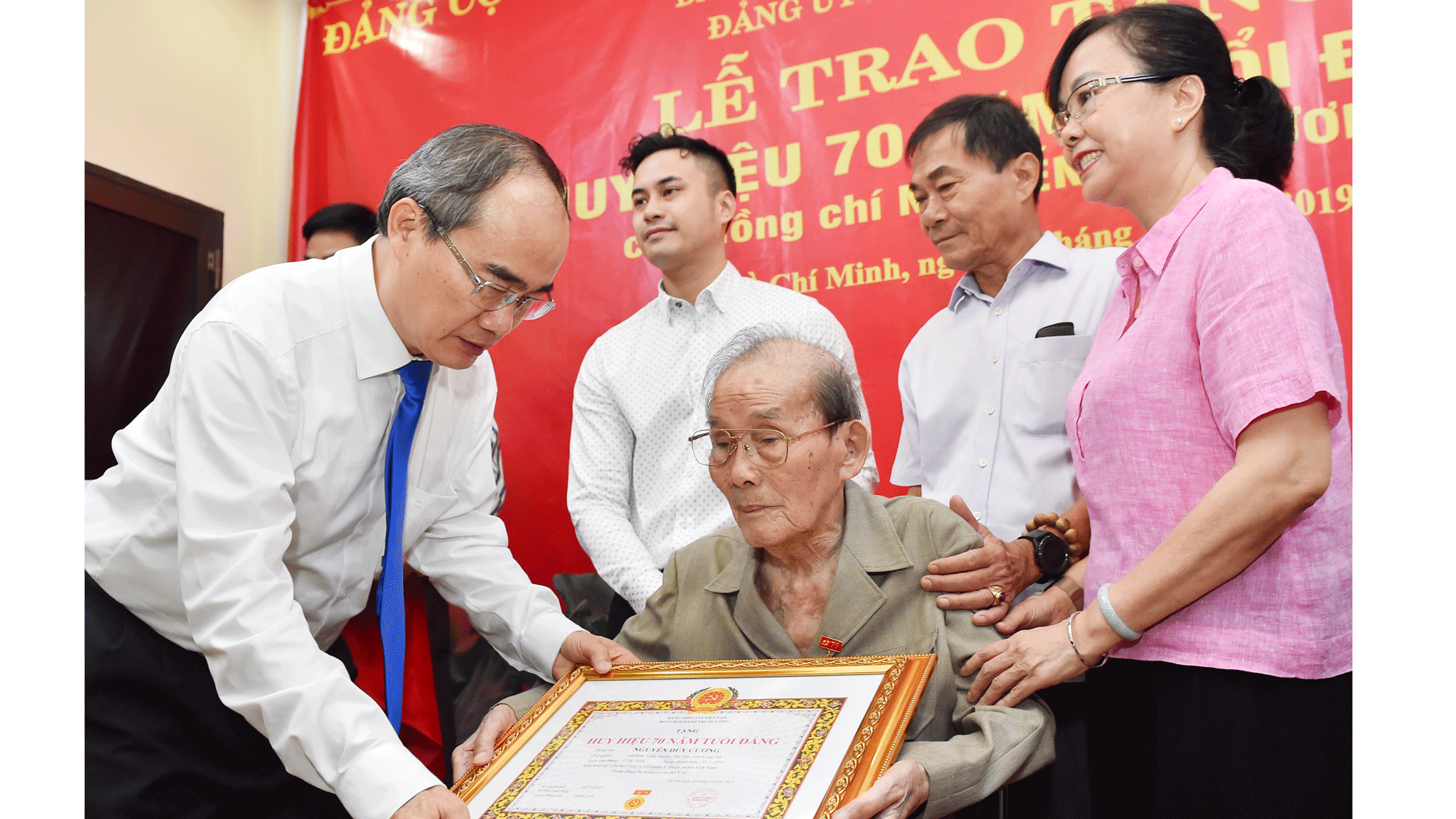 Đồng chí Nguyễn Thiện Nhân, Ủy viên Bộ Chính trị, Bí thư Thành ủy TPHCM, trao Huy hiệu 70 năm tuổi Đảng cho đồng chí Nguyễn Duy Cương. Ảnh: VIỆT DŨNG
