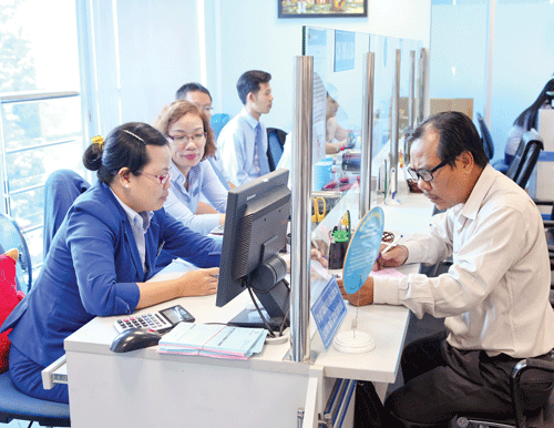 Khách hàng giao dịch tại Eximbank. Ảnh: LONG THANH