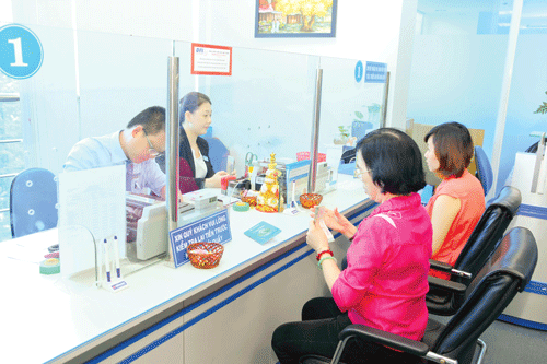 Khách hàng giao dịch tại Eximbank. Ảnh: LONG THANH