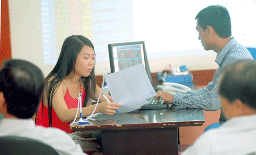 Tư vấn nhà đầu tư theo dõi giá cổ phiếu. Ảnh: C.Thăng