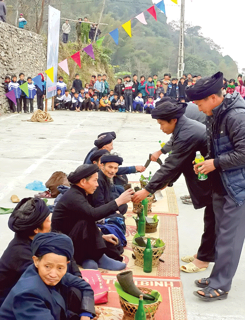 Khách được mời cùng hát giao duyên với người dân tộc La Chí trong tết Khu Cù Tê. Rượu "hoẵng" được đổ vào sừng trâu để các trưởng họ làm lễ.