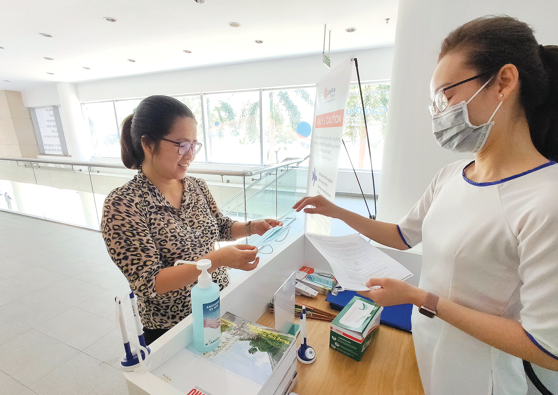 A patient is measured body temperature at a private clinic in Ho Chi Minh City (Photo: SGGP)