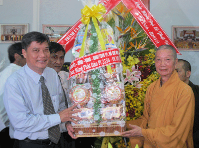 Deputy secretary of the HCMC Party Committee Nguyen Van Dua (L) presents a bouquet to Most Venerable Thich Tri Quang on the birth anniversary of Buddha (Photo: SGGP)