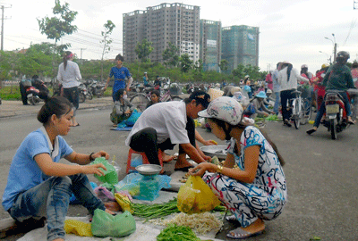 Workers selling vegetables to their colleagues after work, to earn more money to support their families (Photo: SGGP) Workers selling vegetables to their colleagues after work, to earn more money to support their families (Photo: SGGP)