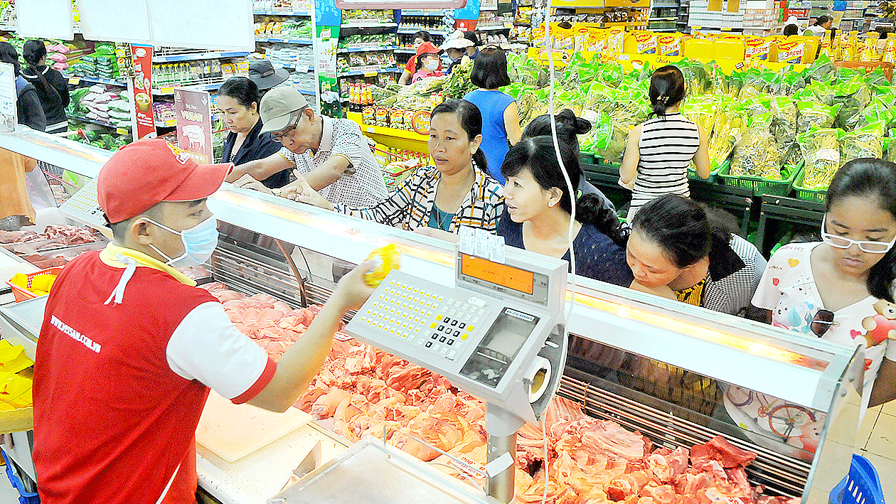 Consumers buy pork at a supermarket. (Photo: SGGP)