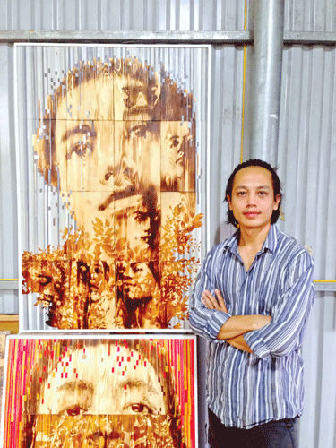 Ngô Văn Sắc bên những bức tranh độc đáo của mình.