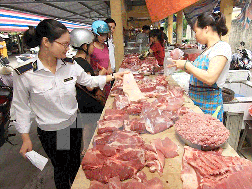 Nhân viên thú y kiểm tra hộ kinh doanh thịt lợn tại chợ.