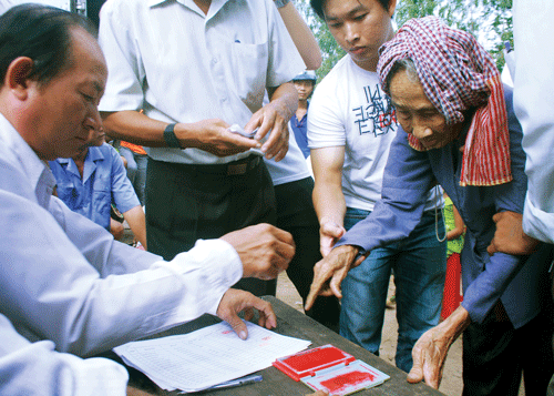 Phần lớn người nghèo ở xã Đa Phước đều không biết chữ, phải điểm chỉ khi làm thủ tục nhận tiền cứu trợ.. Ảnh: M.TRƯỜNG